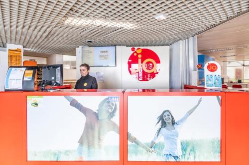 a man and a woman standing at a counter in an office at HI Aveiro – Pousada de Juventude in Aveiro