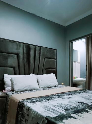 a bedroom with a large bed with a black headboard at Ashridge Guesthouse & Safaris in Hazyview