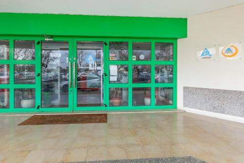 a green room with glass doors in a building at HI Aveiro – Pousada de Juventude in Aveiro