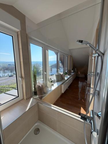 a bathroom with a tub and a large window at RebenQuartier in Klüsserath