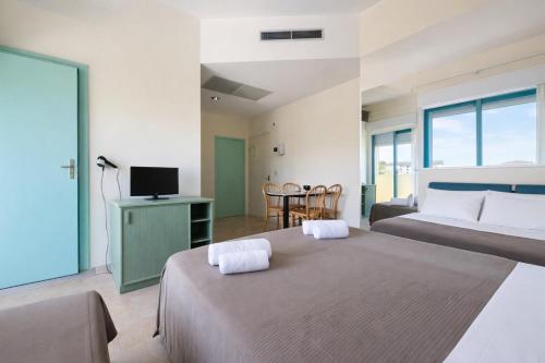 a hotel room with two beds and a television at Bellariva appartamenti in Rimini