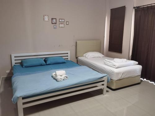 a bedroom with two beds with towels on them at TAcozy693 in Hat Yai