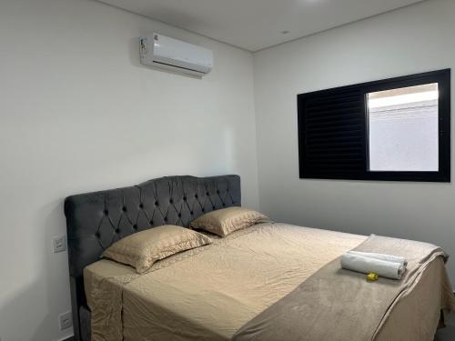 a bed with a black headboard in a bedroom at Mini Palacete in Ribeirão Preto