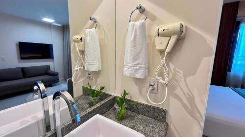 a bathroom with a sink and a phone on the wall at Flat PRAIA de Camburi in Vitória