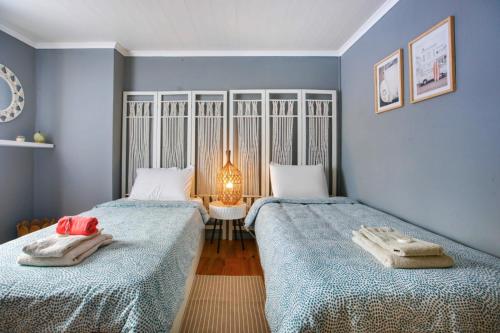 two beds in a room with blue walls at Brisa do Mar in São Roque