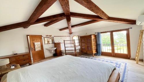 a bedroom with a bed in a room with wooden beams at Villa au calme sans vis à vis in Fayence