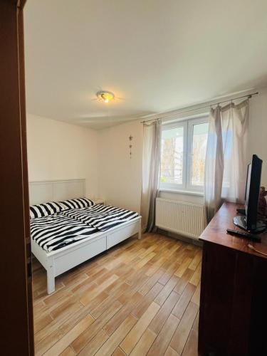 a bedroom with a bed and a wooden floor at Appartamento Nivy con posto auto in Bratislava