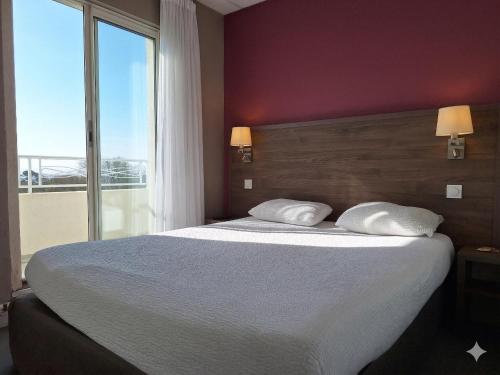 a bedroom with a large bed and a large window at Hotel de la Gare Brest in Brest