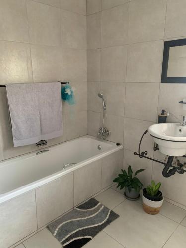 a bathroom with a sink and a bath tub and a sink at Cottage @19th in Pretoria