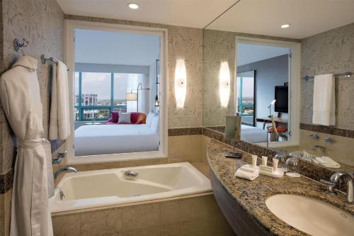 a bathroom with a tub and a large window at The Diplomat Beach Resort Hollywood, Curio Collection by Hilton in Hollywood