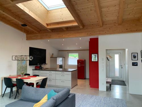 ein Wohnzimmer mit Sofa und Tisch in einer Küche in der Unterkunft Chiemgau Loft in Bad Endorf