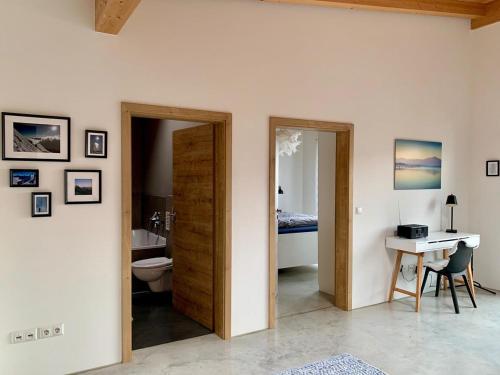 ein Badezimmer mit Toilette, Waschbecken und Schreibtisch in der Unterkunft Chiemgau Loft in Bad Endorf