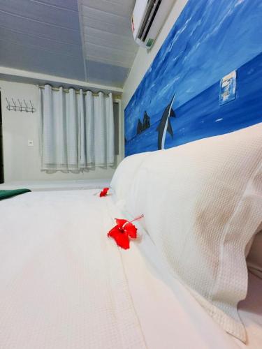 a bedroom with a bed with red flowers on it at Pousada São Silmares in Fernando de Noronha
