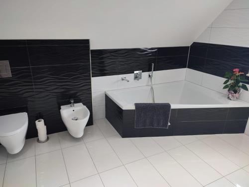 a bathroom with a tub and a toilet and a sink at Haus Katja in Büdelsdorf