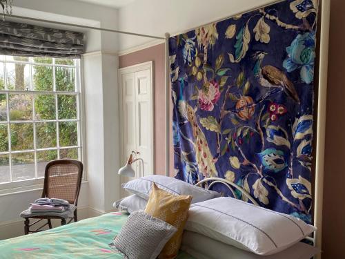 a bedroom with a large floral wallpaper on the wall at Bryn Mair Gardens in Dolgellau