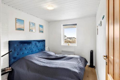a bedroom with a bed with a blue head board at 347-Harboore-Slettevej-71 in Harboør