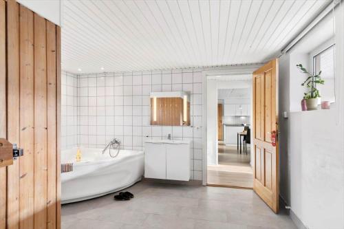 a white bathroom with a tub and a sink at 347-Harboore-Slettevej-71 in Harboør