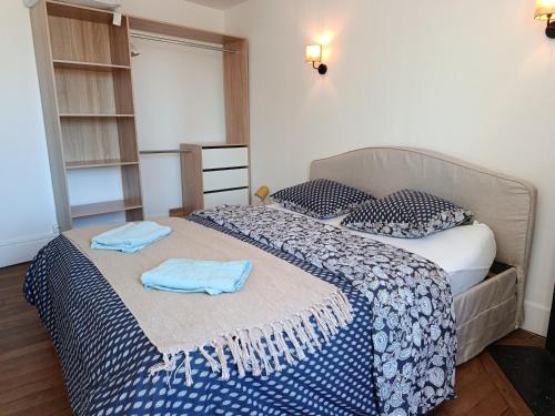 a bedroom with two beds with blue towels on them at Appartement Refait a neuf avec accès au jardin , local vélo et Wifi in La Machine