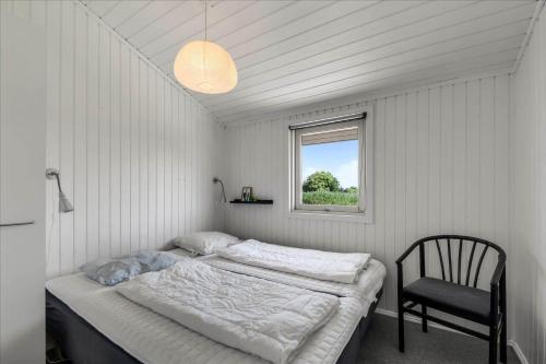 a bedroom with two beds and a chair in it at G195-Lemvig-Porsevej-95 in Lemvig