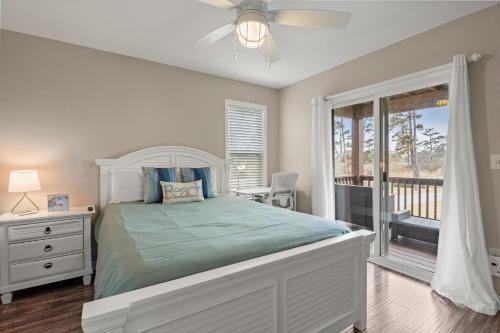 ein weißes Schlafzimmer mit einem Bett und einem Fenster in der Unterkunft Sounds About Wright OBX in Kill Devil Hills