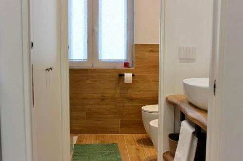 a bathroom with a sink and a toilet and a window at MB House in Sistiana