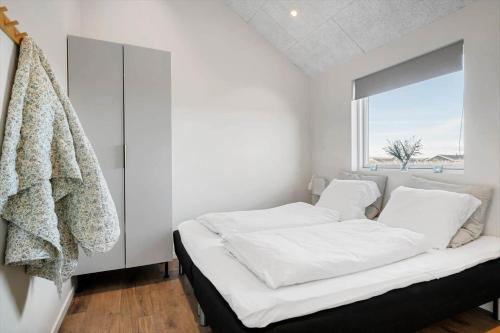 a white bedroom with two beds and a window at 373-Harboore-Slettevej-45 in Harboør