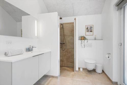 a white bathroom with a toilet and a shower at 373-Harboore-Slettevej-45 in Harboør