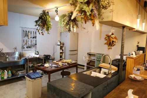 a large kitchen with a table and a counter top at すくもBOX guesthouse in Sukumo