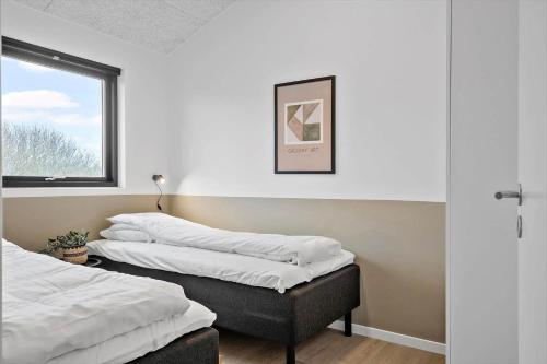 two beds sitting in a room with a window at 371-Harboore-Fourmivej-6 in Harboør