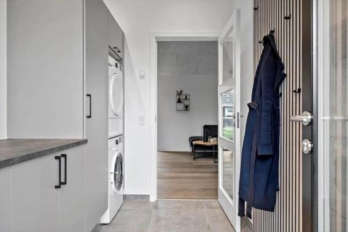 a hallway with a door leading to a laundry room at 371-Harboore-Fourmivej-6 in Harboør