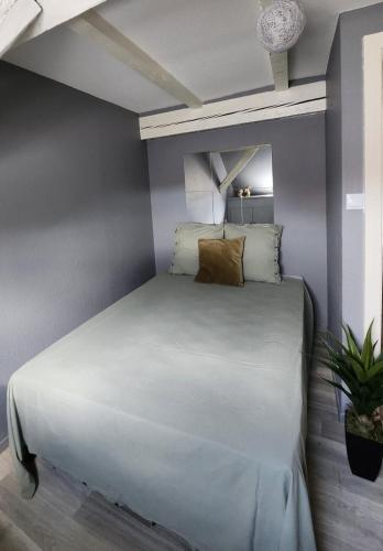 a bed in a room with a gray wall at Bel appartement hyper centre in Sélestat