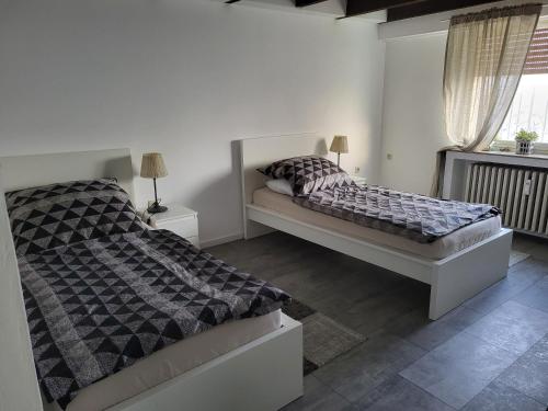 a white bedroom with a bed and a window at Appartement Ferienwohnung in Hövelhof