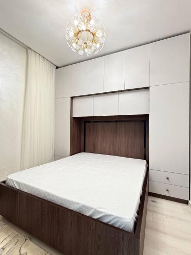 a bedroom with a bed and a chandelier at Modern Luxury Apartment Central Samarkand in Samarkand