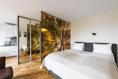 a bedroom with a large bed with a large painting on the wall at Napoleon Hill Apartment in Kaunas