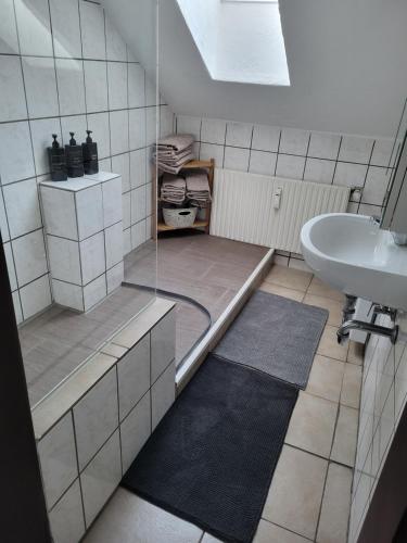 a bathroom with a shower and a sink and a tub at Appartement Ferienwohnung in Hövelhof