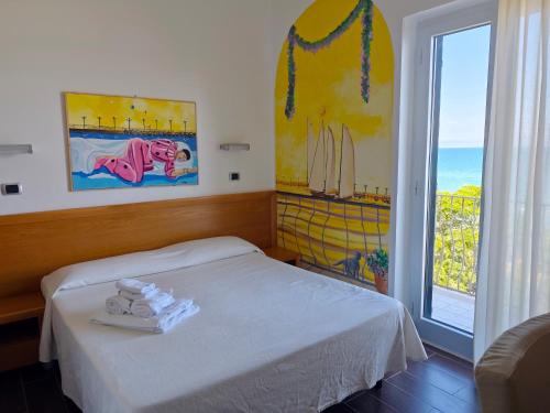 a bedroom with a bed and a large window at Villa Nettuno in San Menaio