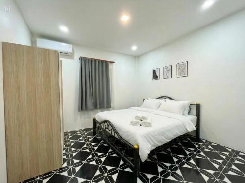 a bedroom with a bed with a black and white floor at Wanderlust Cove in Wok Tum