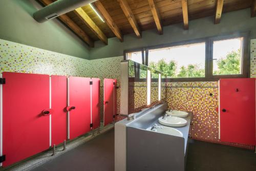 a bathroom with two sinks and red lockers at Bungalows Pirineus in Guils de Cerdaña
