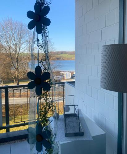 a room with a window with flowers on a table at Modernes Apartment mit Pool und Sauna in Möhnesee