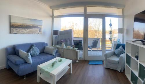 a living room with a blue couch and a table at Modernes Apartment mit Pool und Sauna in Möhnesee