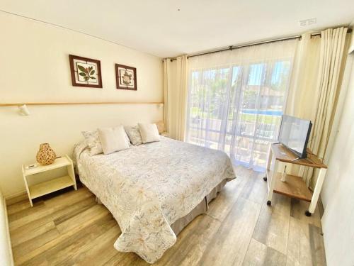 a bedroom with a bed and a tv and a window at Apart hotel Entre Ríos ruta 5 Talca in Talca