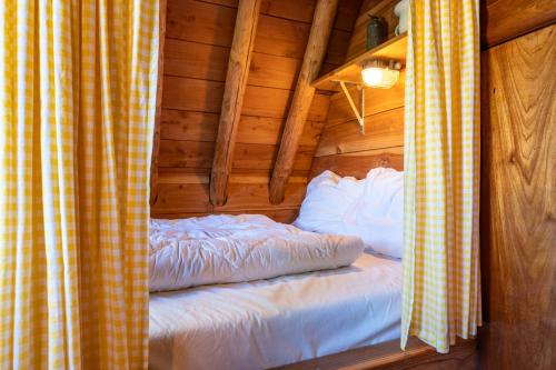 a bedroom with a bed in a log cabin at Unieke plaggenhut in Drenthe met bedstee & uitzicht op wijngaard in Ruinerwold