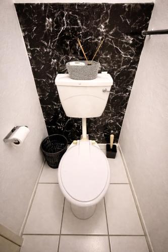 a bathroom with a toilet and a black marble wall at Bonno Guest Suite in Gaborone