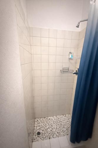 a shower with a blue shower curtain and a tile floor at Bonno Guest Suite in Gaborone