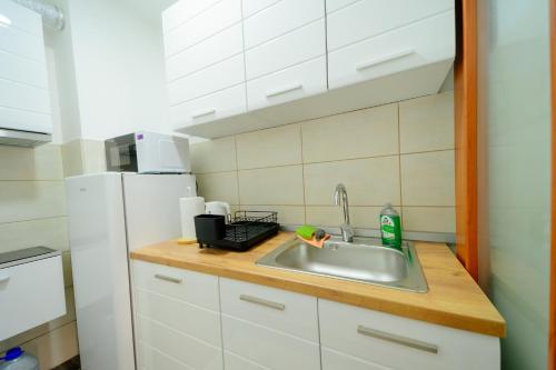 a kitchen with a sink and a refrigerator at Stan na dan DM Uzice in Užice