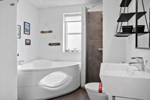 a bathroom with a tub and a toilet and a sink at VK233-Harboore-Doblervej-83 in Harboør