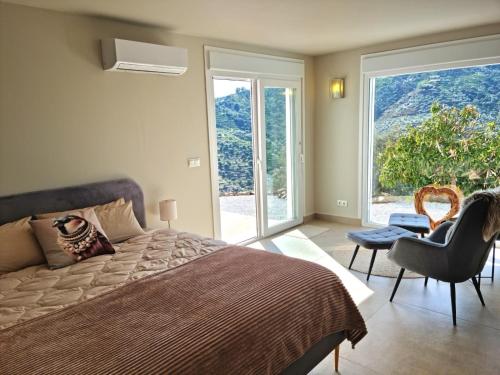 a bedroom with a bed and a large window at Casa La Jolla B&B in Cómpeta