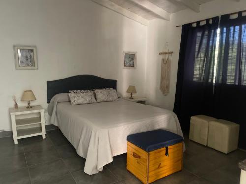 a bedroom with a white bed with a wooden box at Casa Sua in Victoria
