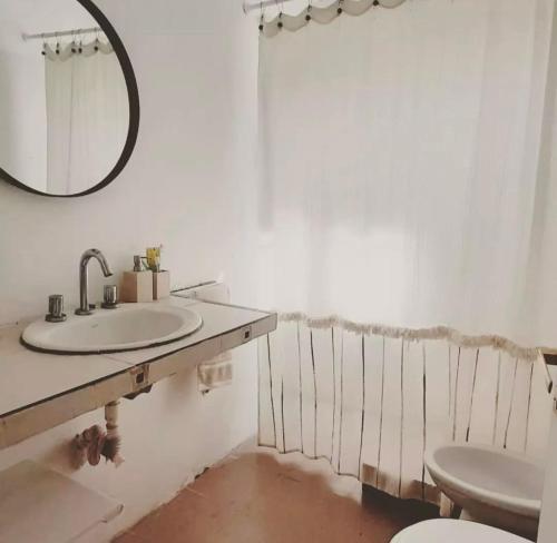 a bathroom with a sink and a toilet and a mirror at Casa Sua in Victoria