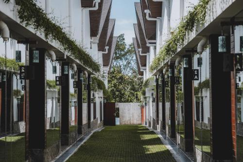 an alleyway between two buildings with plants at Moon Rock Villas Ubud by Ribas in Gianyar